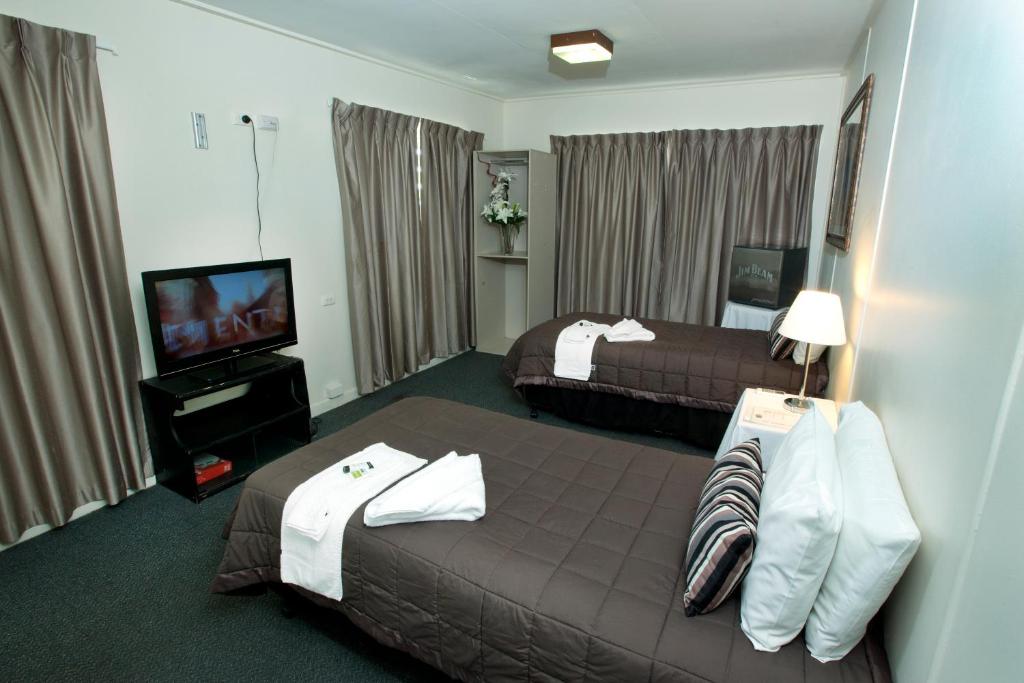 a hotel room with two beds and a television at Windsor Hotel Motel Dalby in Dalby