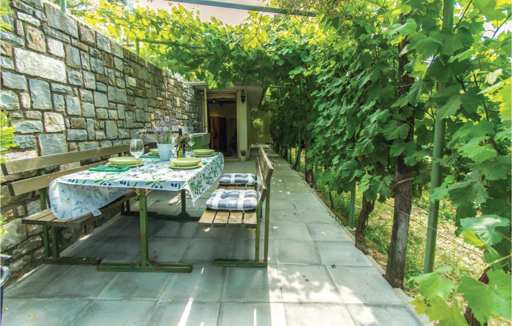 un patio con tavolo e sedie in giardino di Gorgeous Apartment In Strunjan With Kitchen a Strunjan