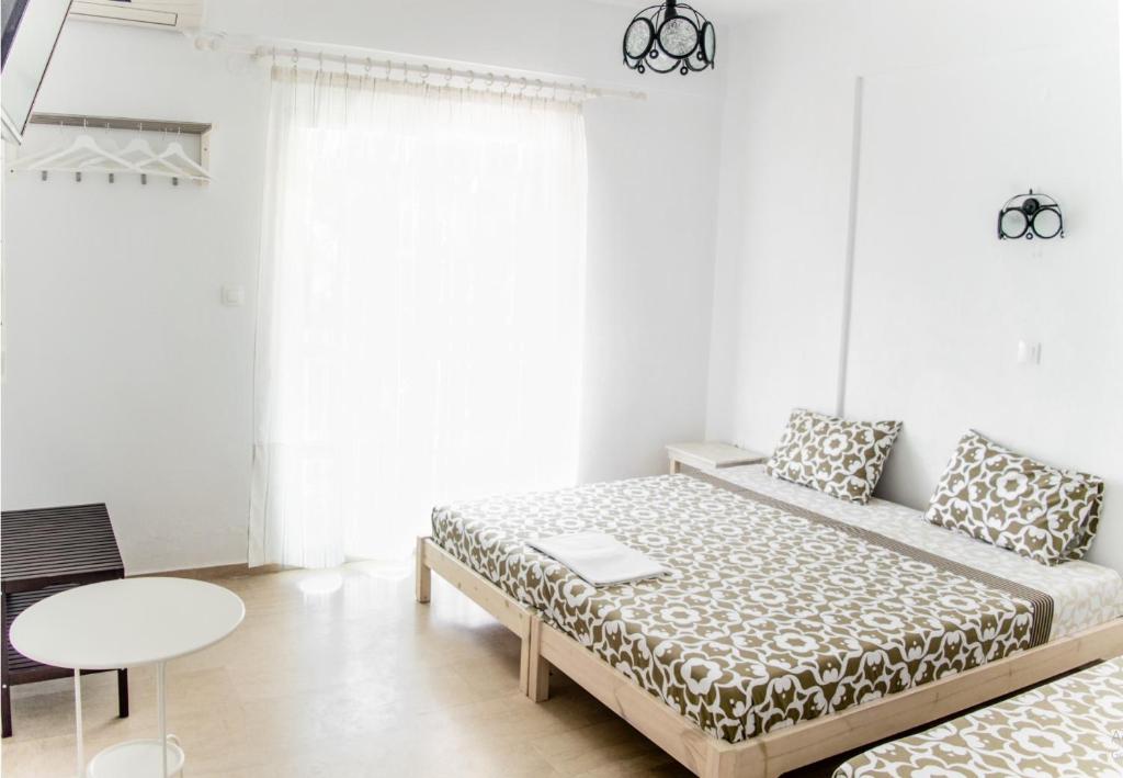 a white room with a bed and a table at House Charistos in Neos Marmaras