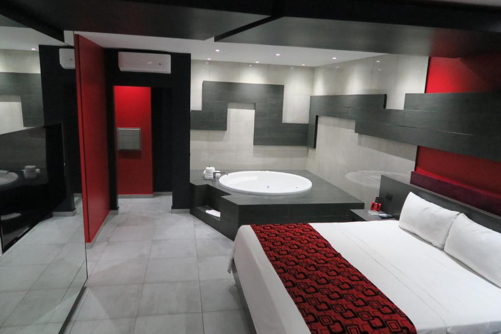 a bedroom with a bed and a bathroom with a sink at Motel Boutique Xpress in Ensenada