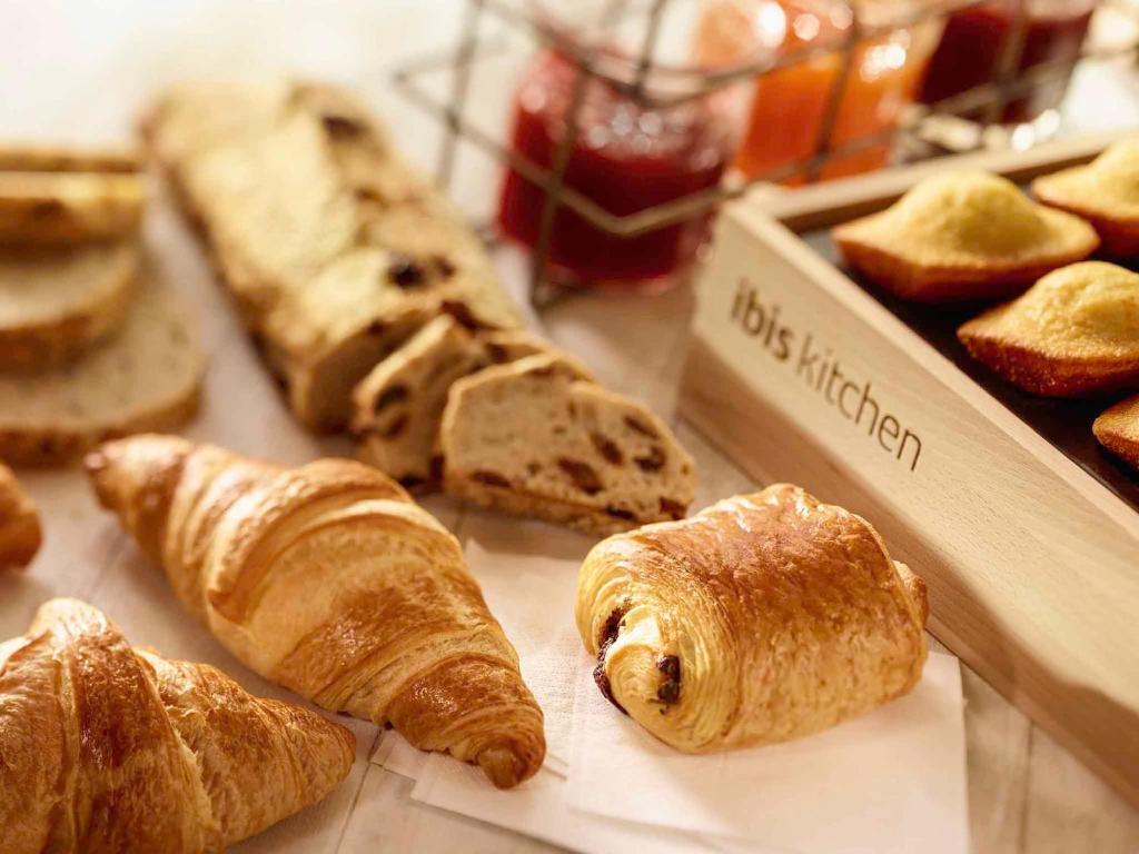 a table with a bunch of bread and pastries at Ibis Hong Kong Central & Sheung Wan in Hong Kong
