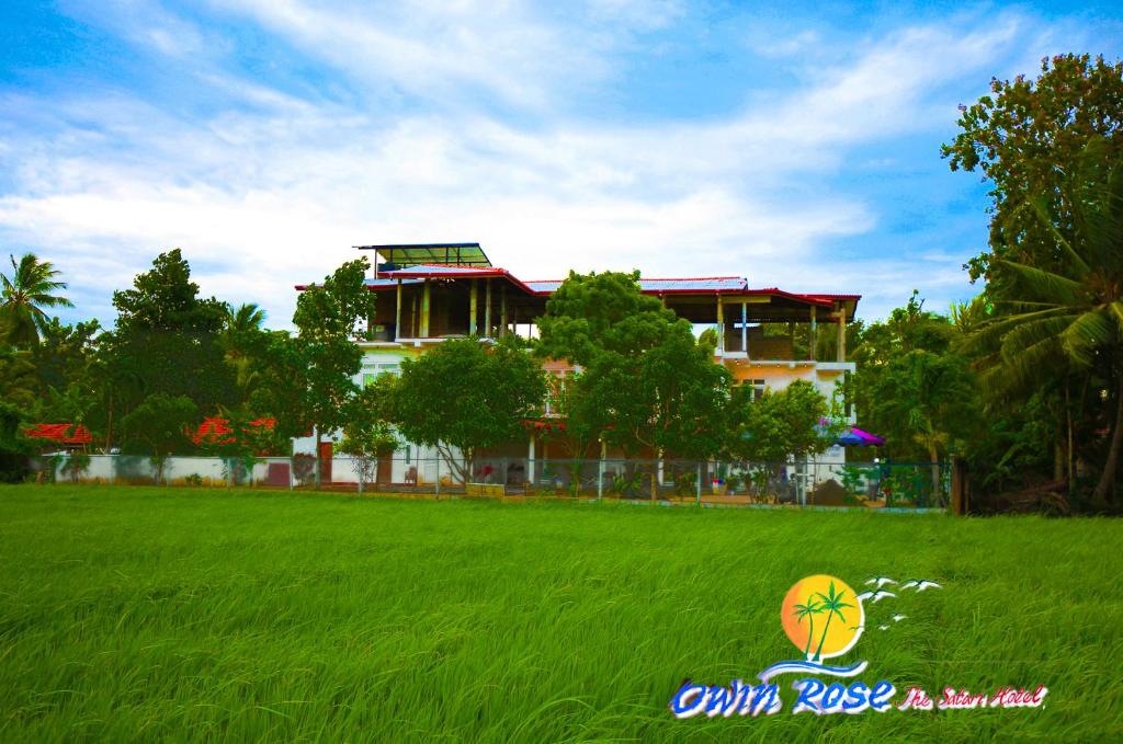 a building in the middle of a field of grass at Owin Rose Yala Safari Hotel in Tissamaharama