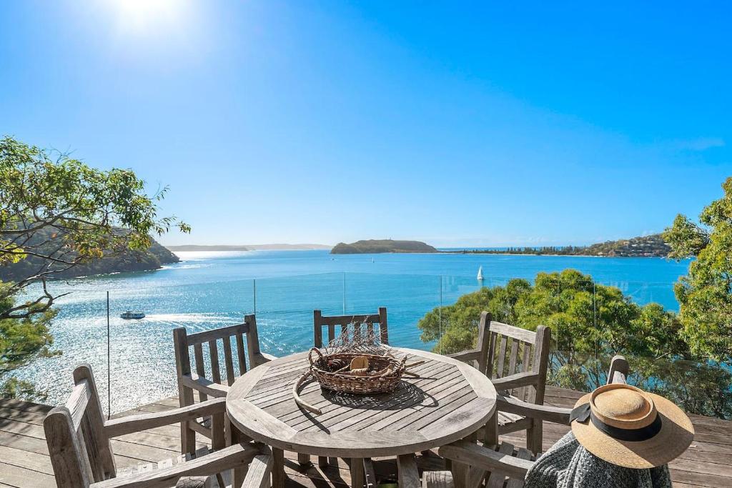 a picnic table with a view of the ocean at Cape Mackerel Cabin with Magic Palm Beach & Pittwater Views in Great Mackerel Beach