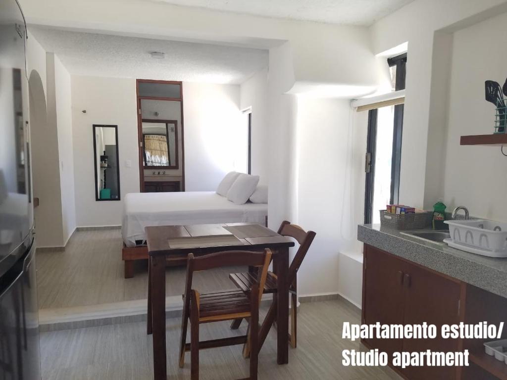 1 dormitorio con cama, mesa y cocina en Casa Kay en Playa del Carmen