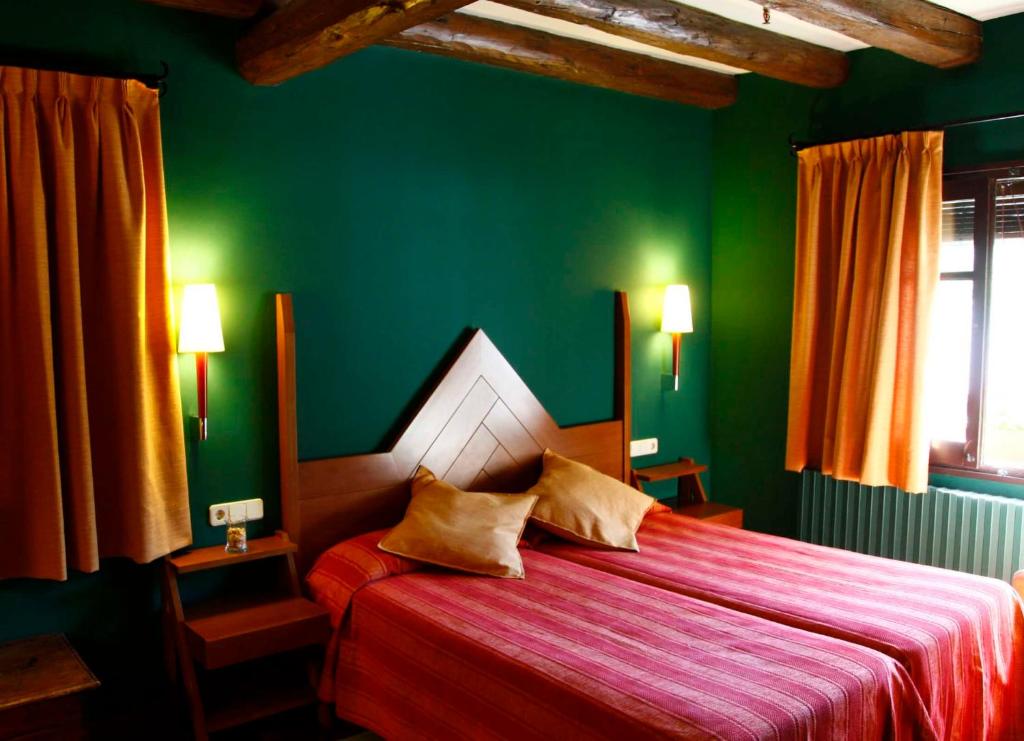a hotel room with a bed and two lamps at Hotel Vall Ferrera in Areu