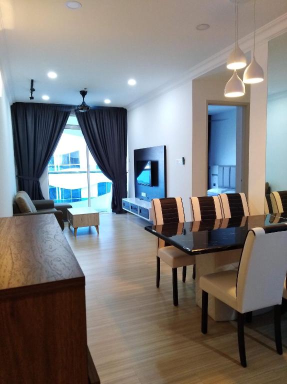 a living room with a table and chairs and a television at The Wave Residence in Malacca