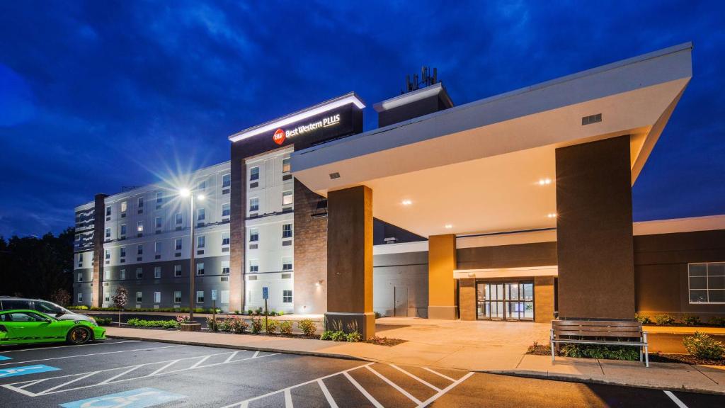 a hotel with a car parked in a parking lot at Best Western Plus Wilkes Barre-Scranton Airport Hotel in Pittston