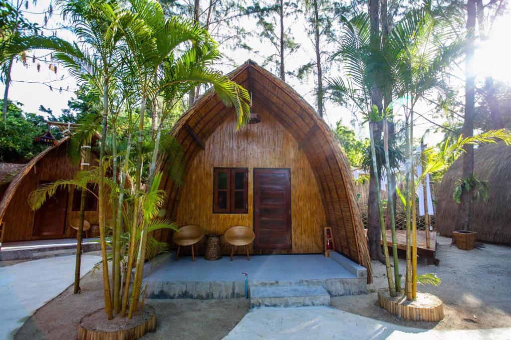 a small house with a round roof with palm trees at Cicada Lanta in Ko Lanta