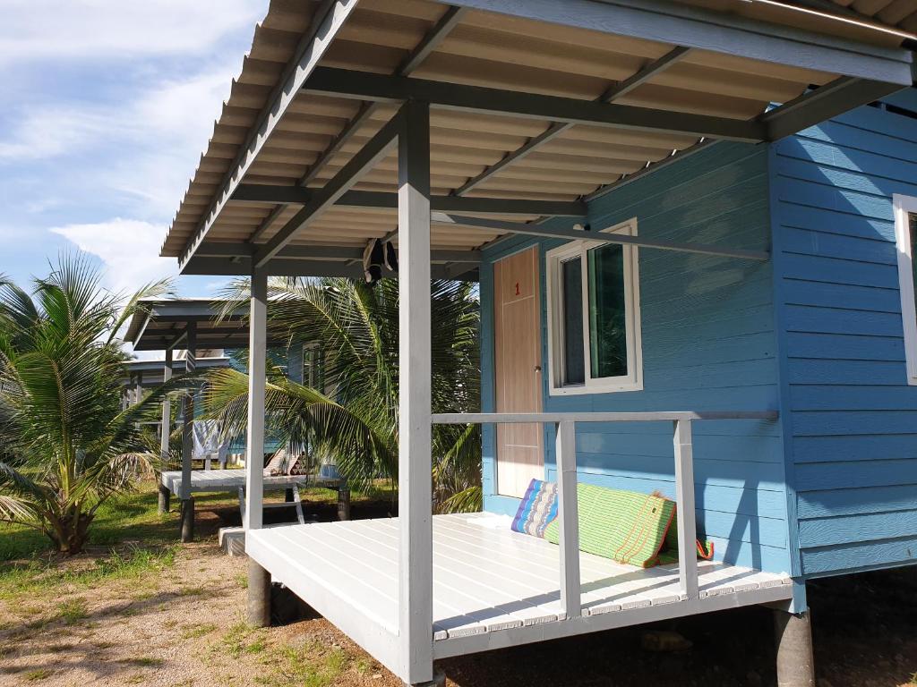 a blue tiny house with a porch and a window at Baan Suan Coconut Ko Yao Noi in Ko Yao Noi