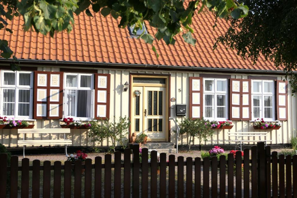 uma casa com um telhado laranja e uma cerca em Kapitänshaus in Strandnähe in Prerow em Prerow