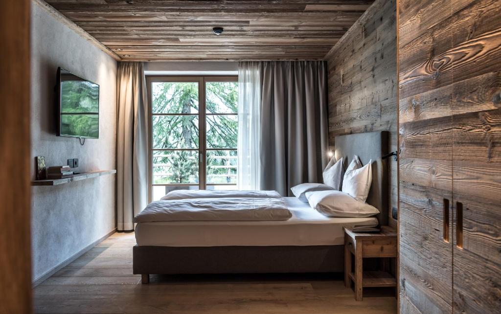 sypialnia z łóżkiem i oknem w obiekcie Chalet Cogolara w mieście Colfosco