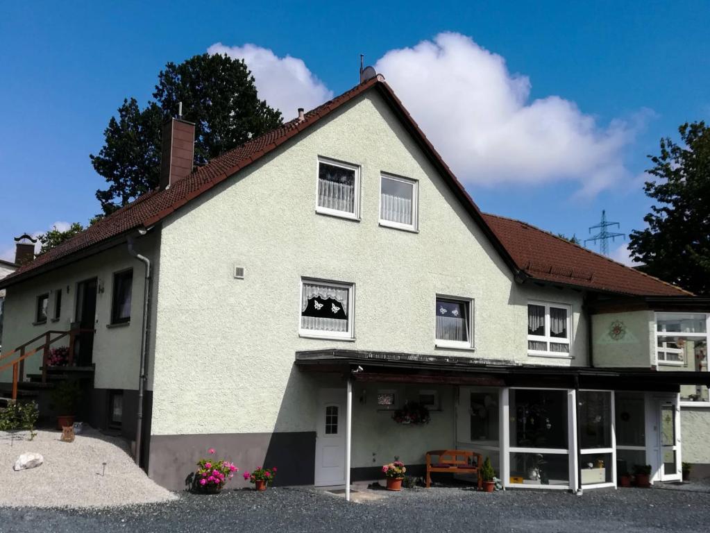 una gran casa blanca con techo rojo en Ferienwohnung Preuß, en Martinlamitz