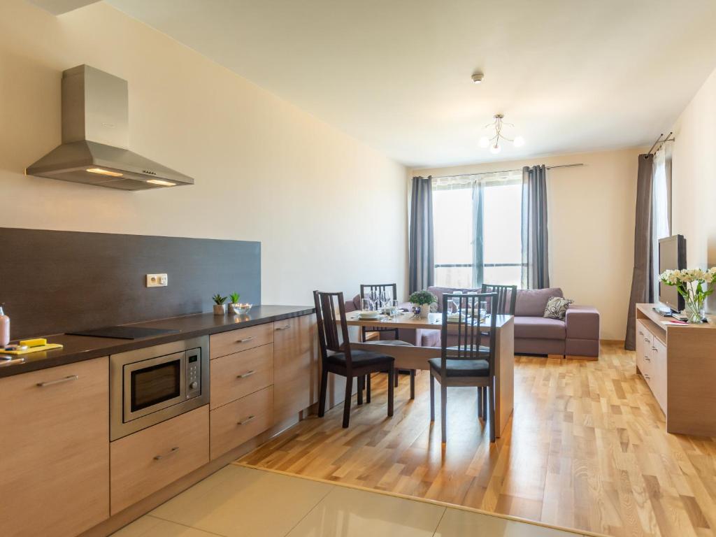 a kitchen and living room with a table and chairs at VacationClub – Olympic Park Apartament A503 in Kołobrzeg