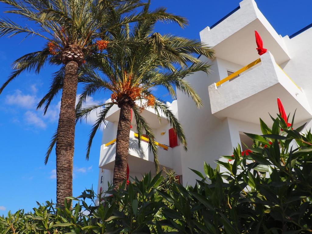 een gebouw met palmbomen ervoor bij Apartamentos Mallorca SL in Cala Millor