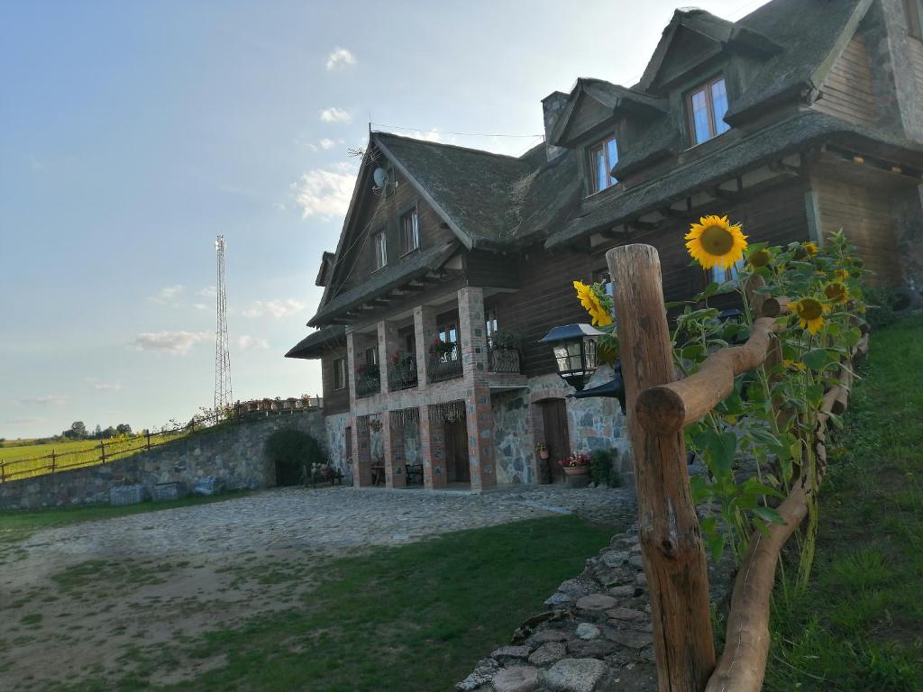 a house with a sunflower in front of it at Mazurska Knieja in Miłakowo
