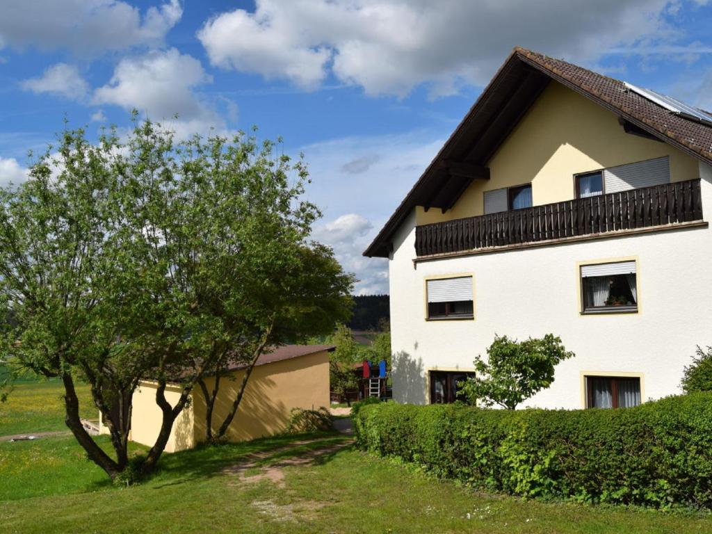 Una casa blanca con un árbol delante. en Ferienhaus Herzog en Haundorf