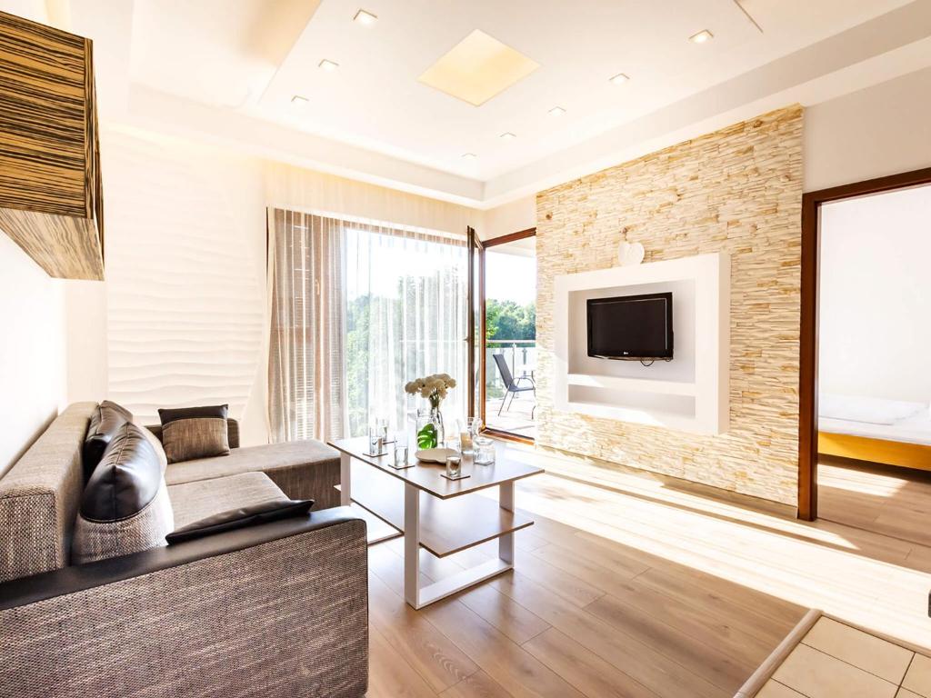 a living room with a couch and a tv at VacationClub – Baltic Park Plaża 22 Apartament 4.2.3. in Świnoujście