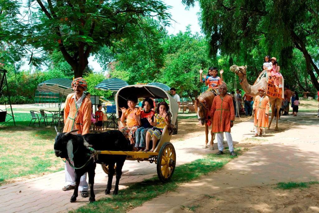 um grupo de pessoas montadas numa carruagem puxada por cavalos em Best Western Resort Country Club em Gurgaon