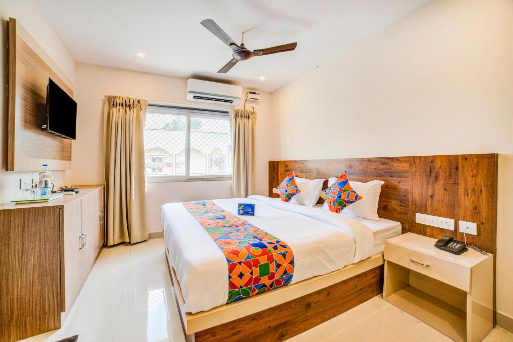 a hotel room with a bed and a television at FabHotel Spark Inn Dwarakanagar in Vijayawāda