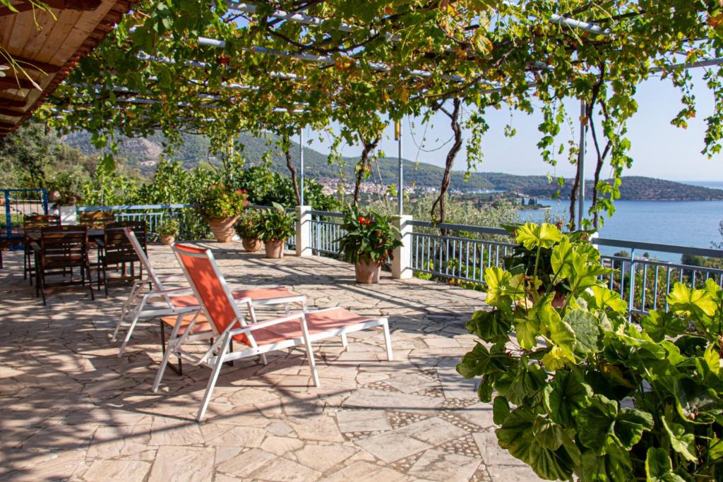 a patio with chairs and tables and a view of the water at Villa Krassi in Ancient Epidauros