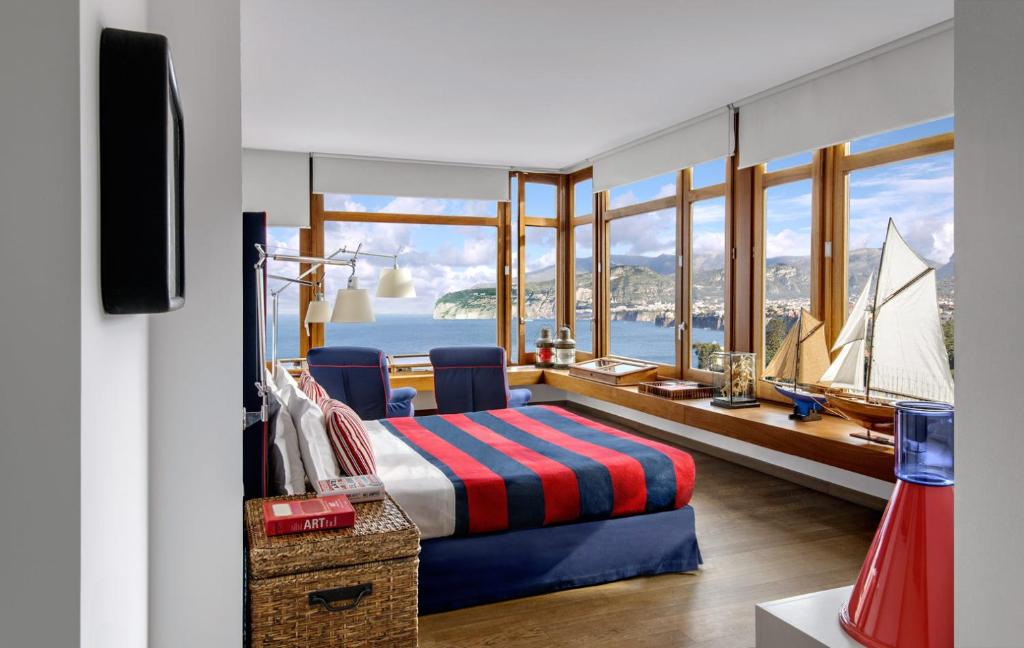 una camera con un letto e una barca a vela in una finestra di Maison La Minervetta a Sorrento