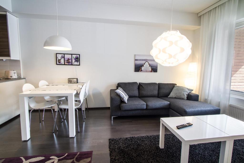 een woonkamer met een bank en een tafel bij Kotimaailma Apartments Turku in Turku