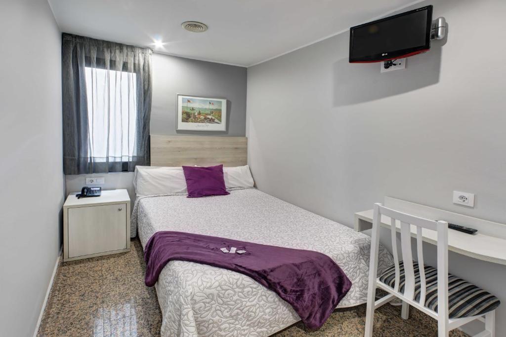 A bed or beds in a room at Hotel Nuevo Triunfo