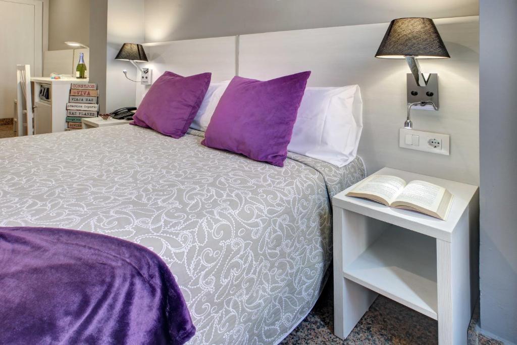 A bed or beds in a room at Hotel Nuevo Triunfo