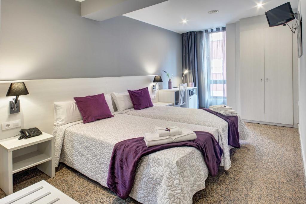 A bed or beds in a room at Hotel Nuevo Triunfo