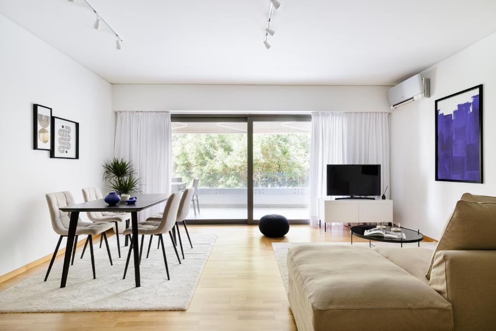 a living room with a table and a couch at Modern 1BD Apartment close to the Acropolis Museum by UPSTREET in Athens