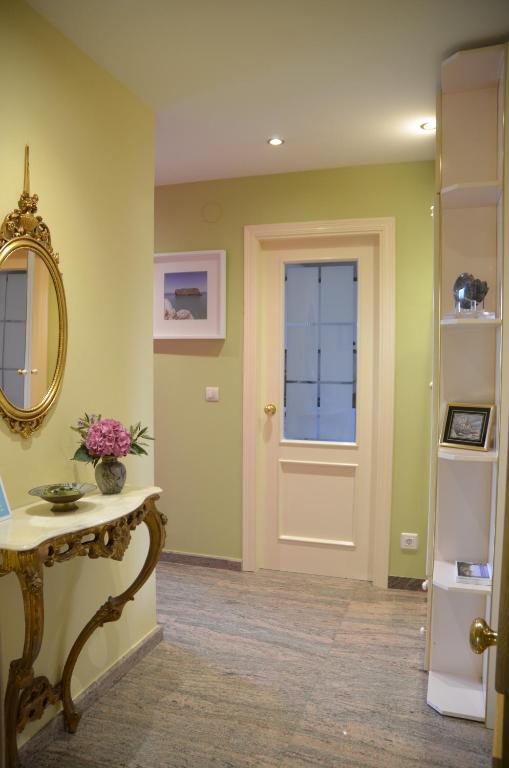 a hallway with a door and a table and a mirror at Apartamento Tere in Llanes