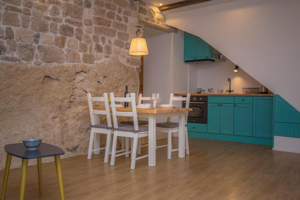 een keuken met groene kasten en een tafel en stoelen bij 2 Cannons/Old Town in Šibenik