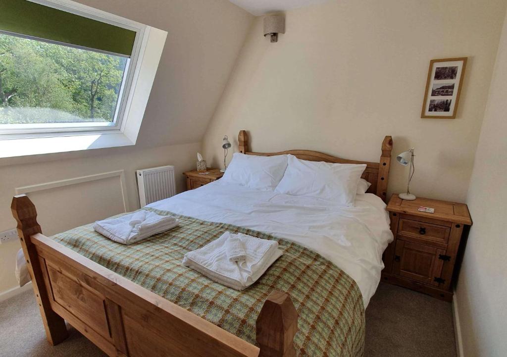 a bedroom with a bed with white sheets and a window at Plas Penaeldroch Manor in Dolwyddelan