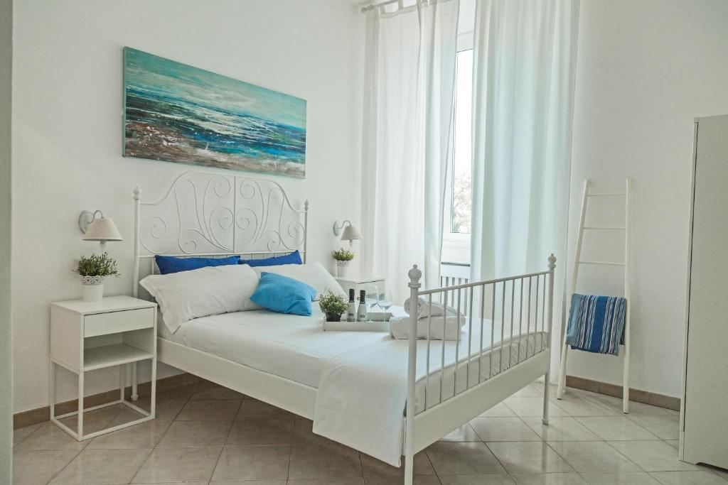 a white bedroom with a bed and a window at River View in Fiumicino