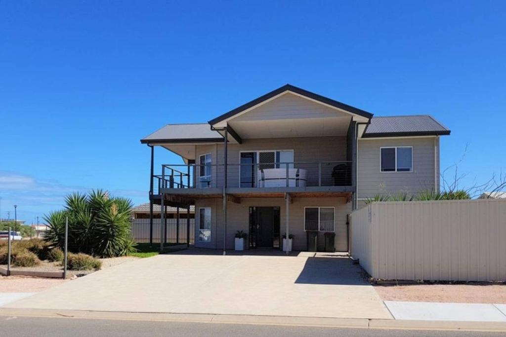 a large house with a fence in front of it at Agape Holiday Home with Pool table ,NBN Internet in Wallaroo