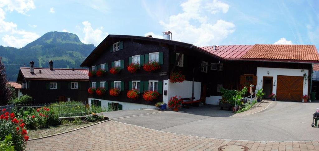 a black house with flowers on the side of it at Ferienwohnung Baumgartner in Bad Hindelang