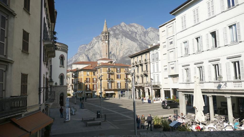 a city street with buildings and a mountain in the background at La Casa sul Lago Lecco in Lecco