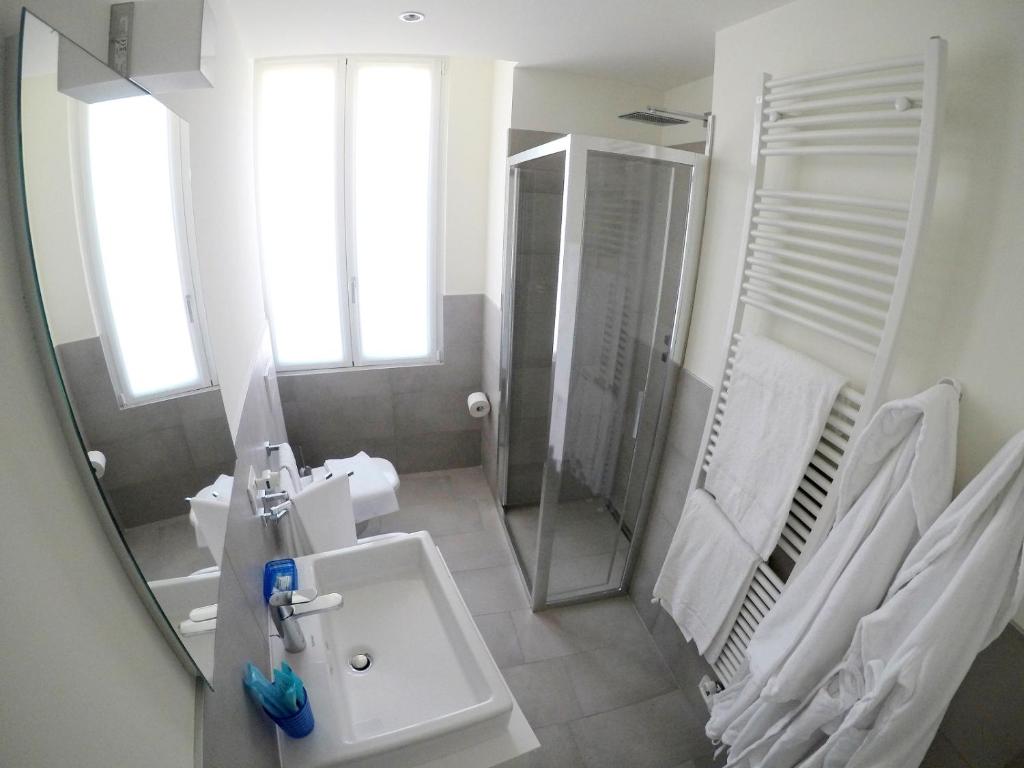 a bathroom with a sink and a shower and a mirror at La Casa sul Lago Lecco in Lecco