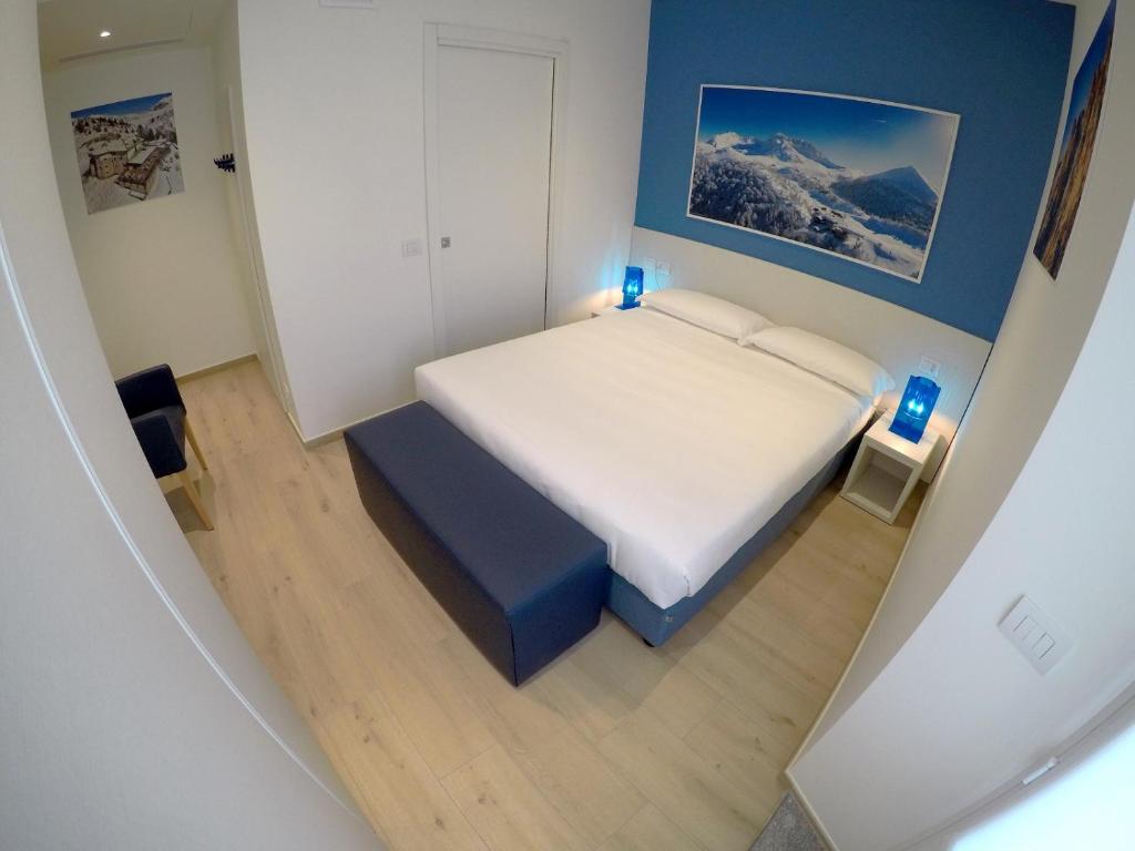 a small bedroom with a white bed and blue lights at La Casa sul Lago Lecco in Lecco