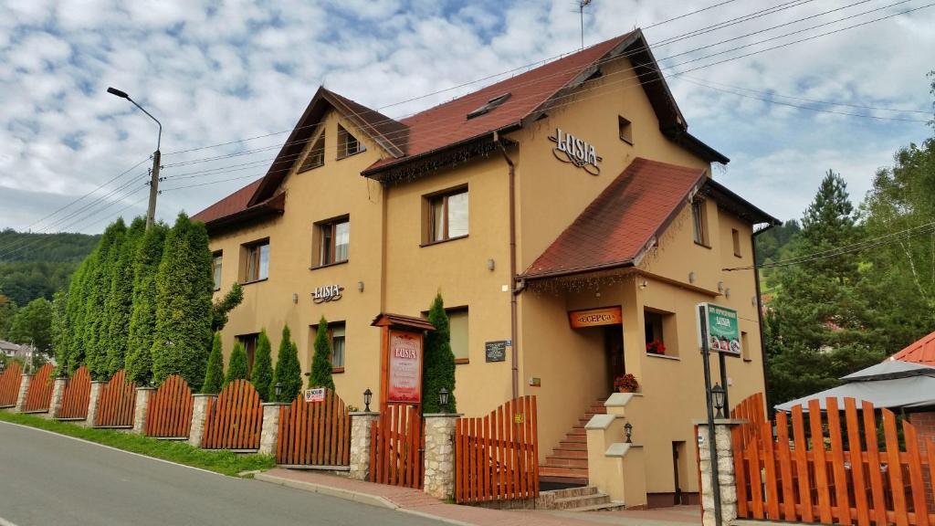 a yellow house with a orange fence in front of it at Lusia in Wisła