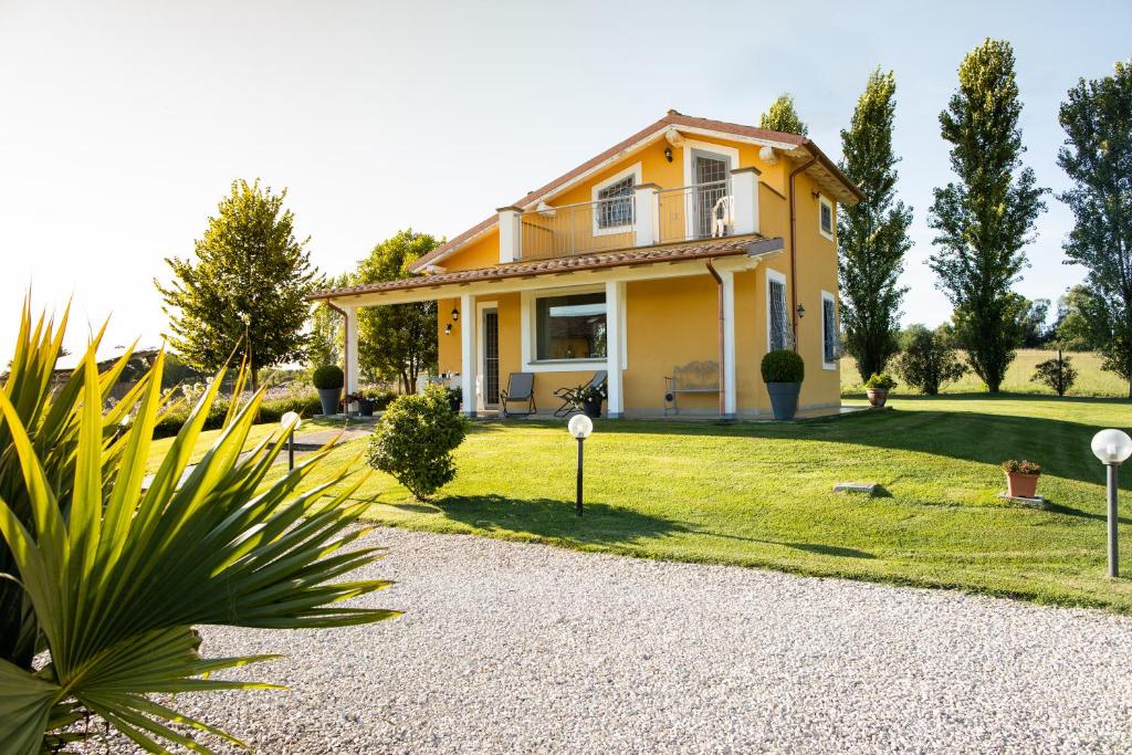 a yellow house with a garden and a driveway at Villa la casa di Siro in Bracciano