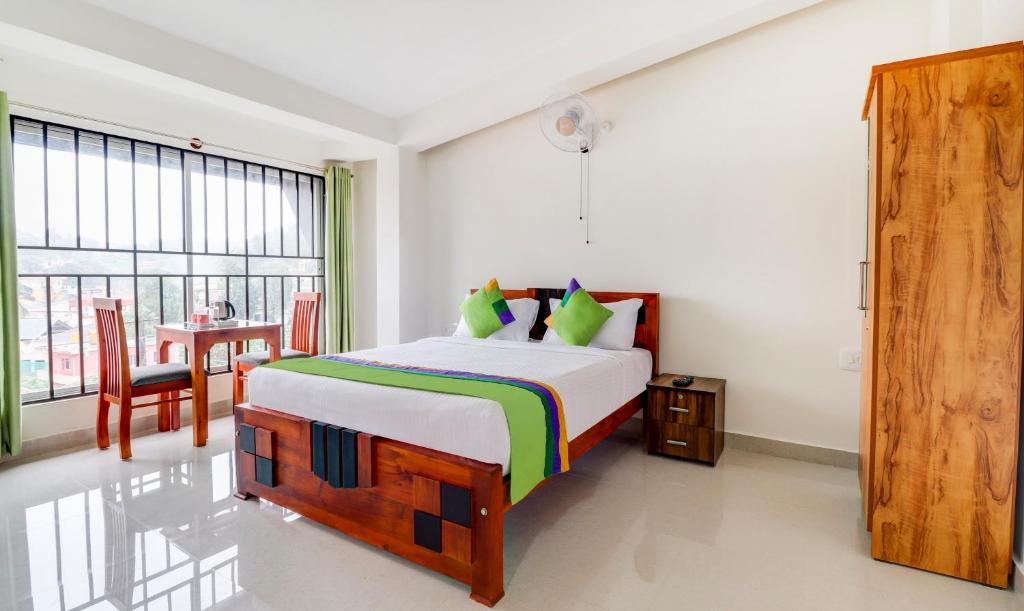 een slaapkamer met een groot bed en een tafel bij Treebo Trend New Redfern - Madikeri in Madikeri