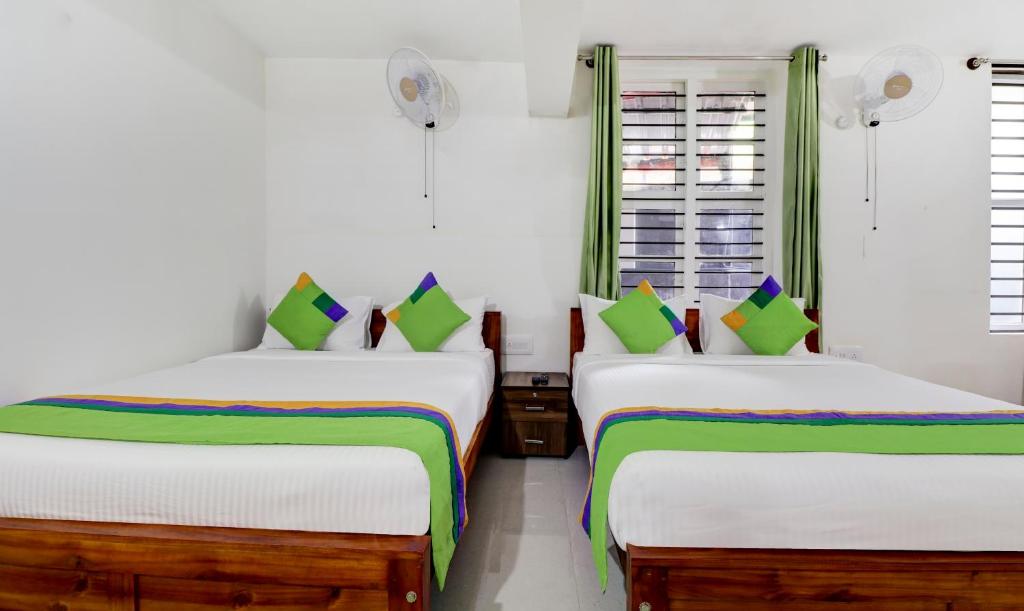 Postel nebo postele na pokoji v ubytování Treebo New Redfern, Madikeri