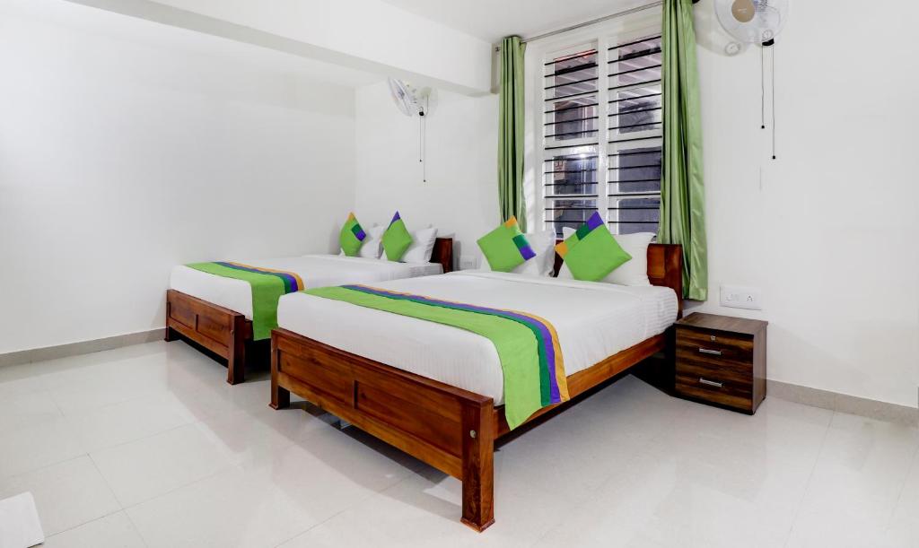 Postel nebo postele na pokoji v ubytování Treebo New Redfern, Madikeri