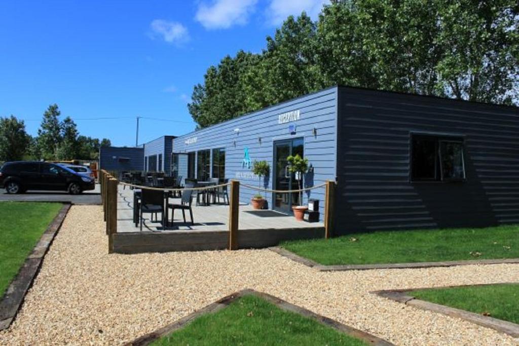 ein kleines Haus mit einer Terrasse und einem Tisch in der Unterkunft The Bay Colwell in Freshwater