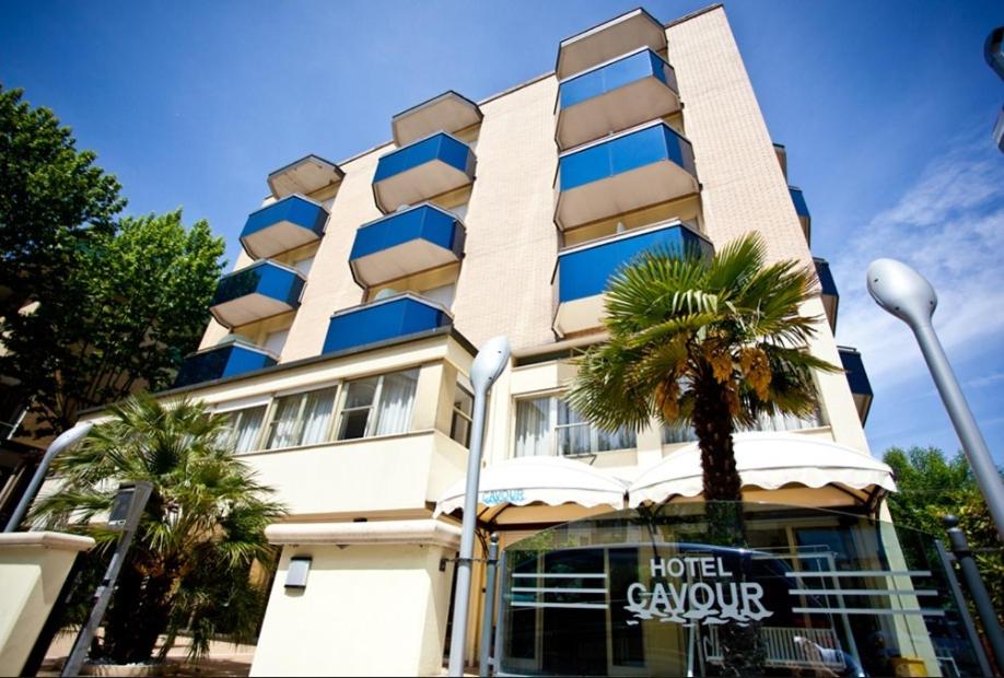 a hotel lobby with a palm tree in front of a building at Hotel Cavour in Cesenatico