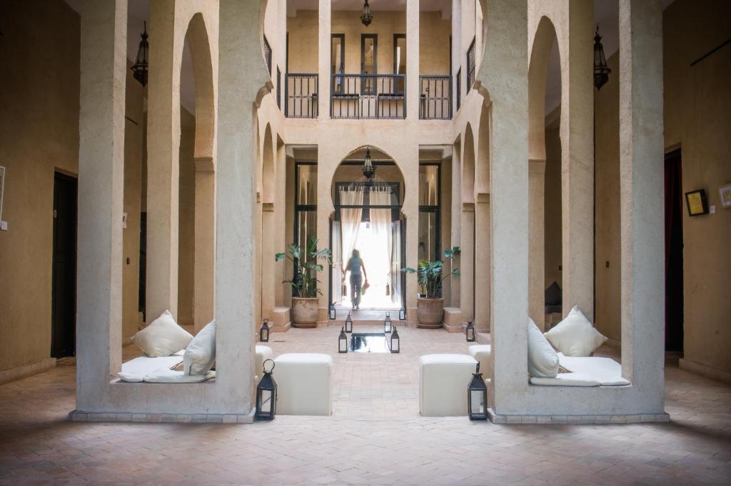 a hallway with white chairs and a person in the distance at Dar Chamaa in Ouarzazate