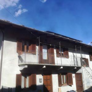 a building with a balcony on the side of it at Appartamento Vacanza l'Alouette in Villar Pellice
