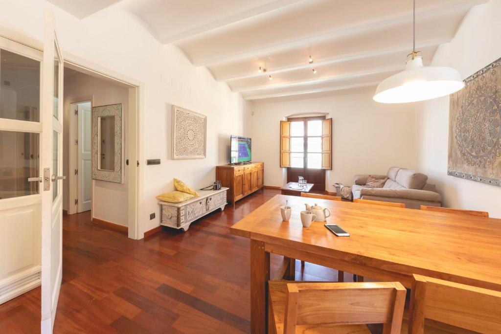 uma sala de estar com uma mesa e um sofá em Bravissimo Mercaders 6 em Girona