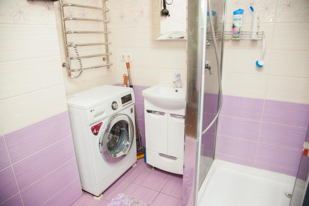 a bathroom with a washing machine and a sink at 2 Rooms Luxury Apartment on Divnogorskaya 13 Street in Zaporozhye